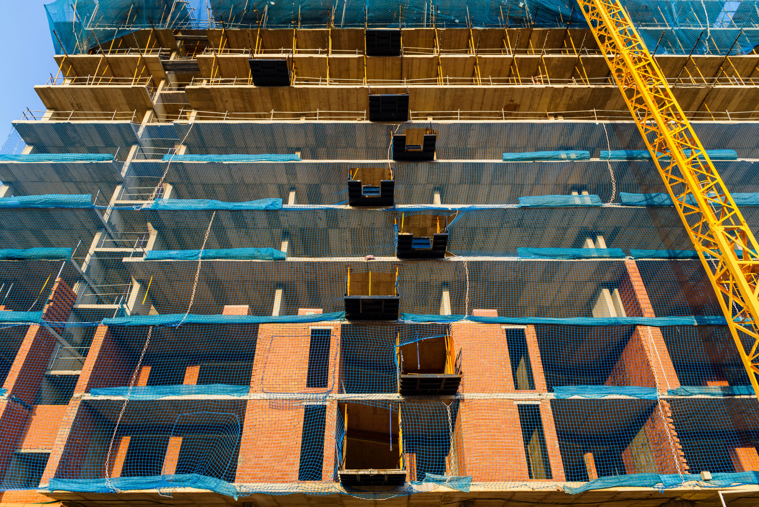 Valencia, Spain - July 3, 2019: Yellow crane on a construction site to lift large weights of construction material.